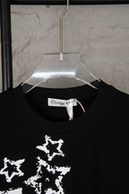 Black T-shirt neckline with white star print visible and Christian Dior neck label
