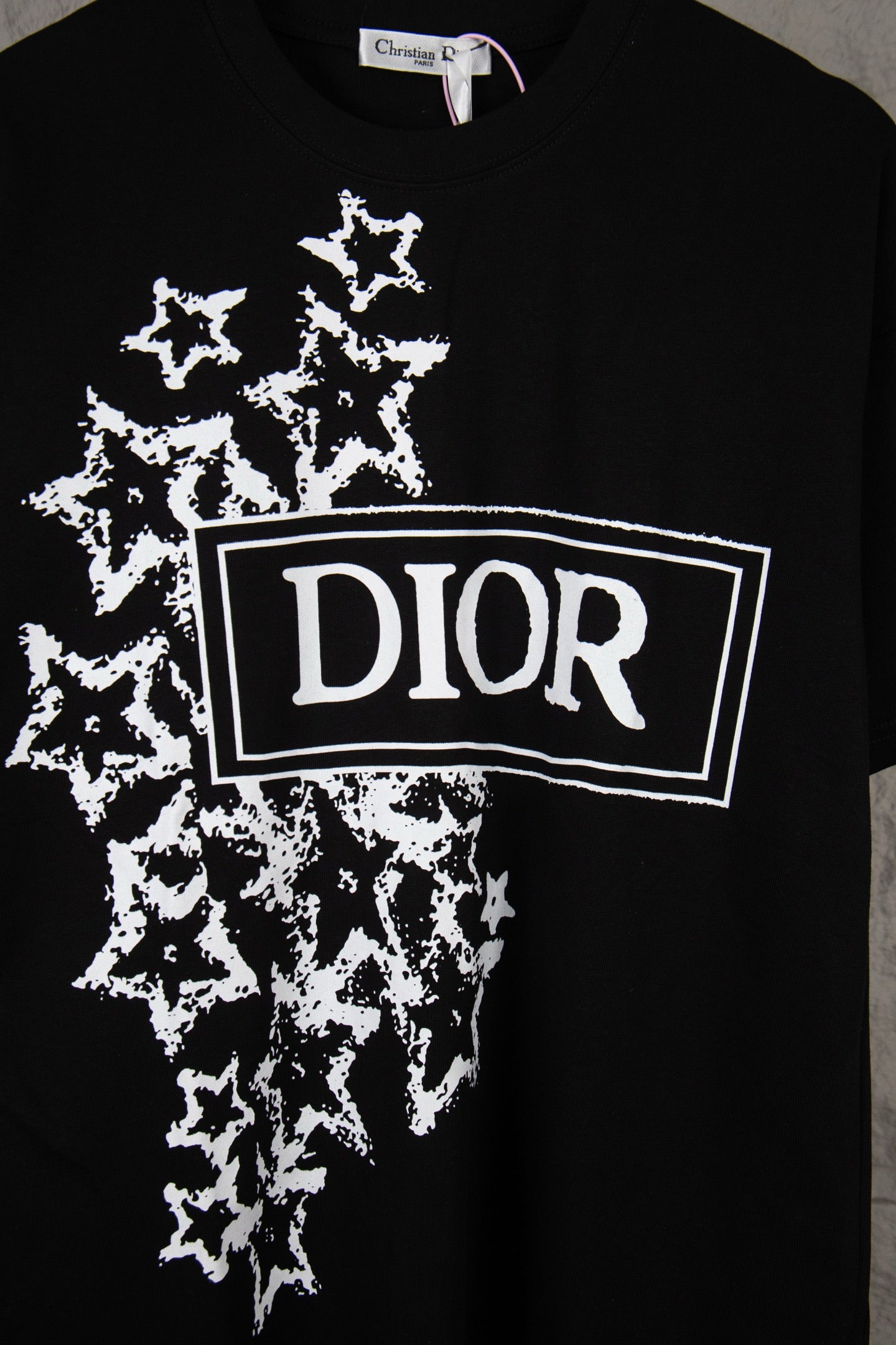 Black short-sleeve T-shirt with large white DIOR logo and starburst pattern