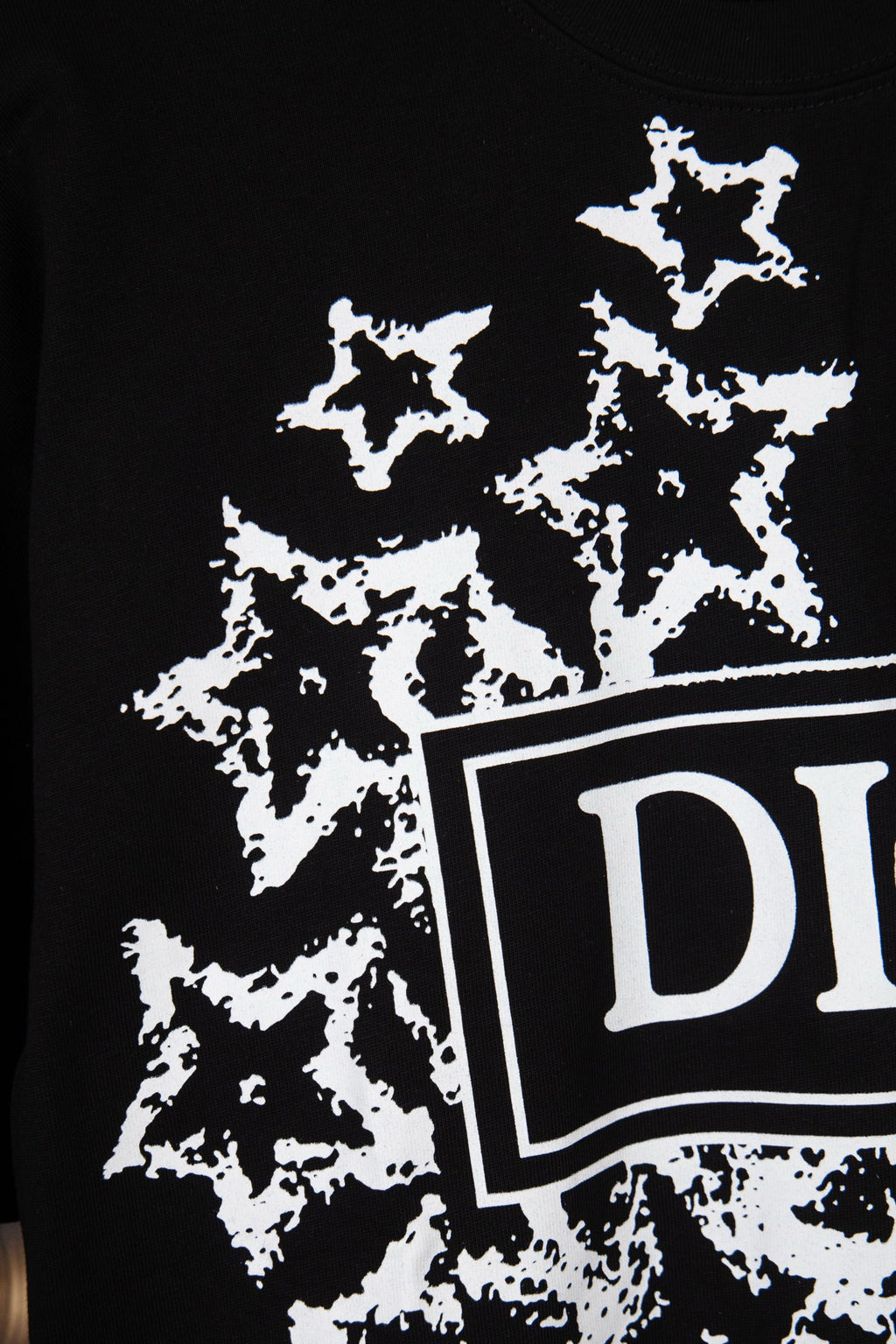 Black short-sleeve T-shirt with white starburst print and DIOR logo edge detail