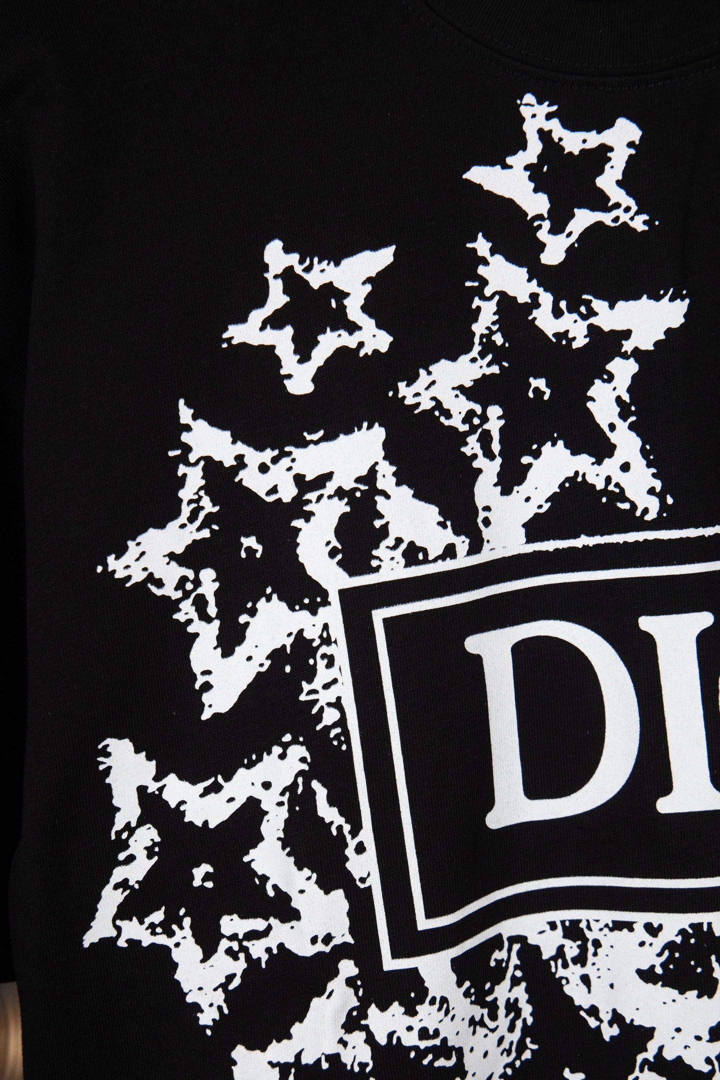 Black short-sleeve T-shirt with white starburst print and DIOR logo edge detail