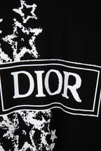 Black T-shirt close-up: white DIOR logo banner over starburst print
