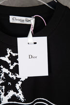 Black T-shirt with white star print and Dior brand hang tag at the collar