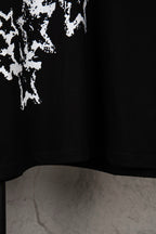 Black T-shirt lower hem with partial white starburst print