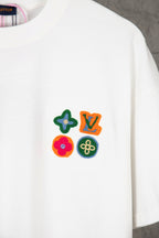 White Louis Vuitton T-shirt with colorful flower and star patch graphic