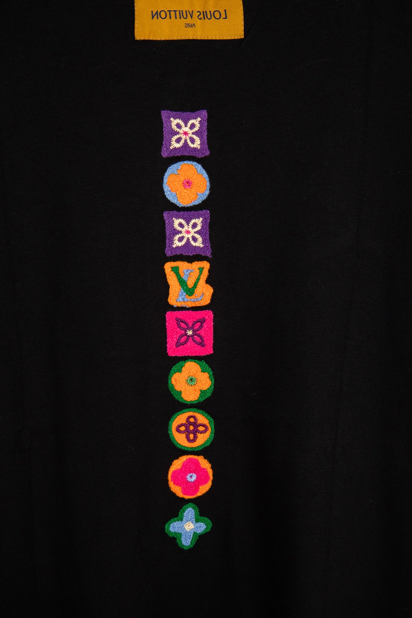 Black T-shirt with stacked multicolor embroidered icons on back