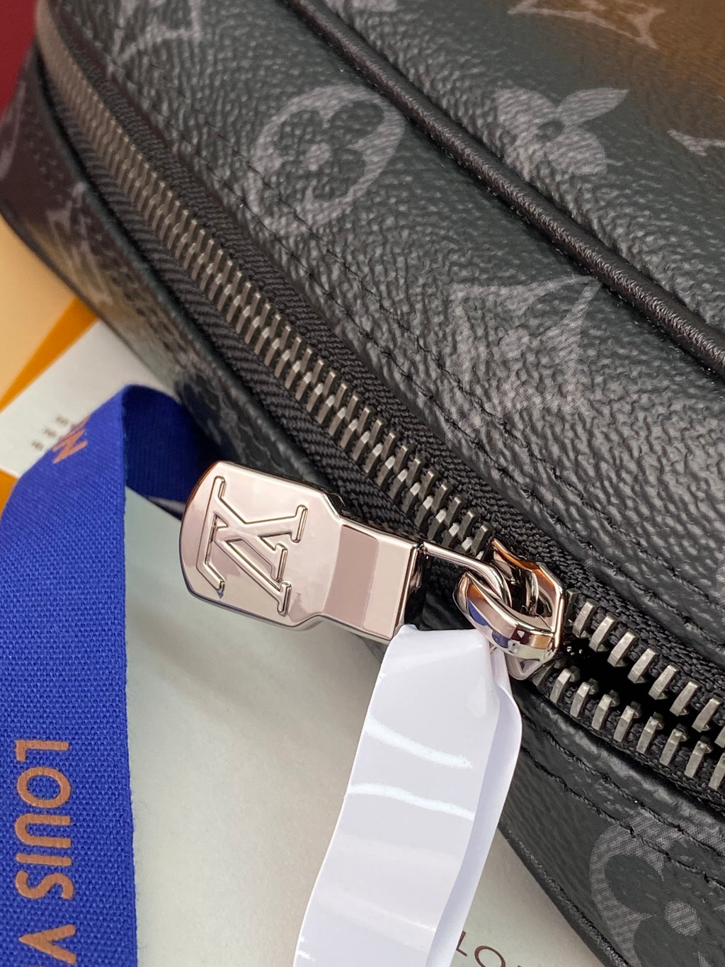 Small Louis Vuitton monogram bag zipper pull with metal logo detail