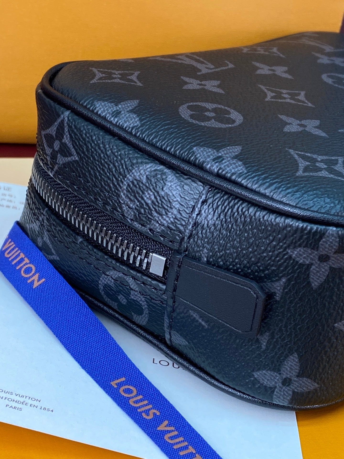 Louis Vuitton monogram belt bag style with front zipper and rectangular leather tab