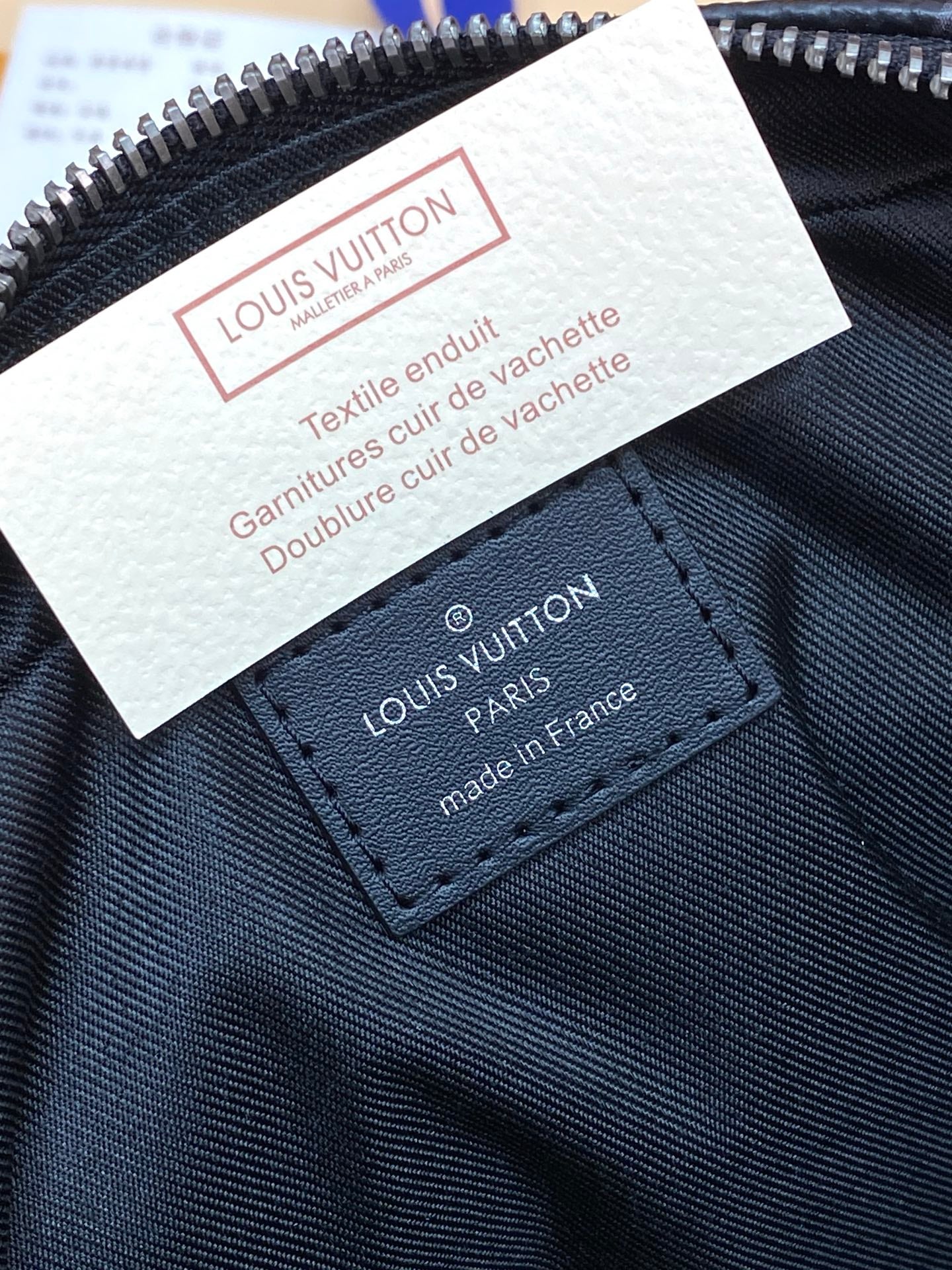 Louis Vuitton small men bag label and stitched logo patch near zipper