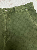 Green Gucci shorts waistband with button closure and stitched detailing.