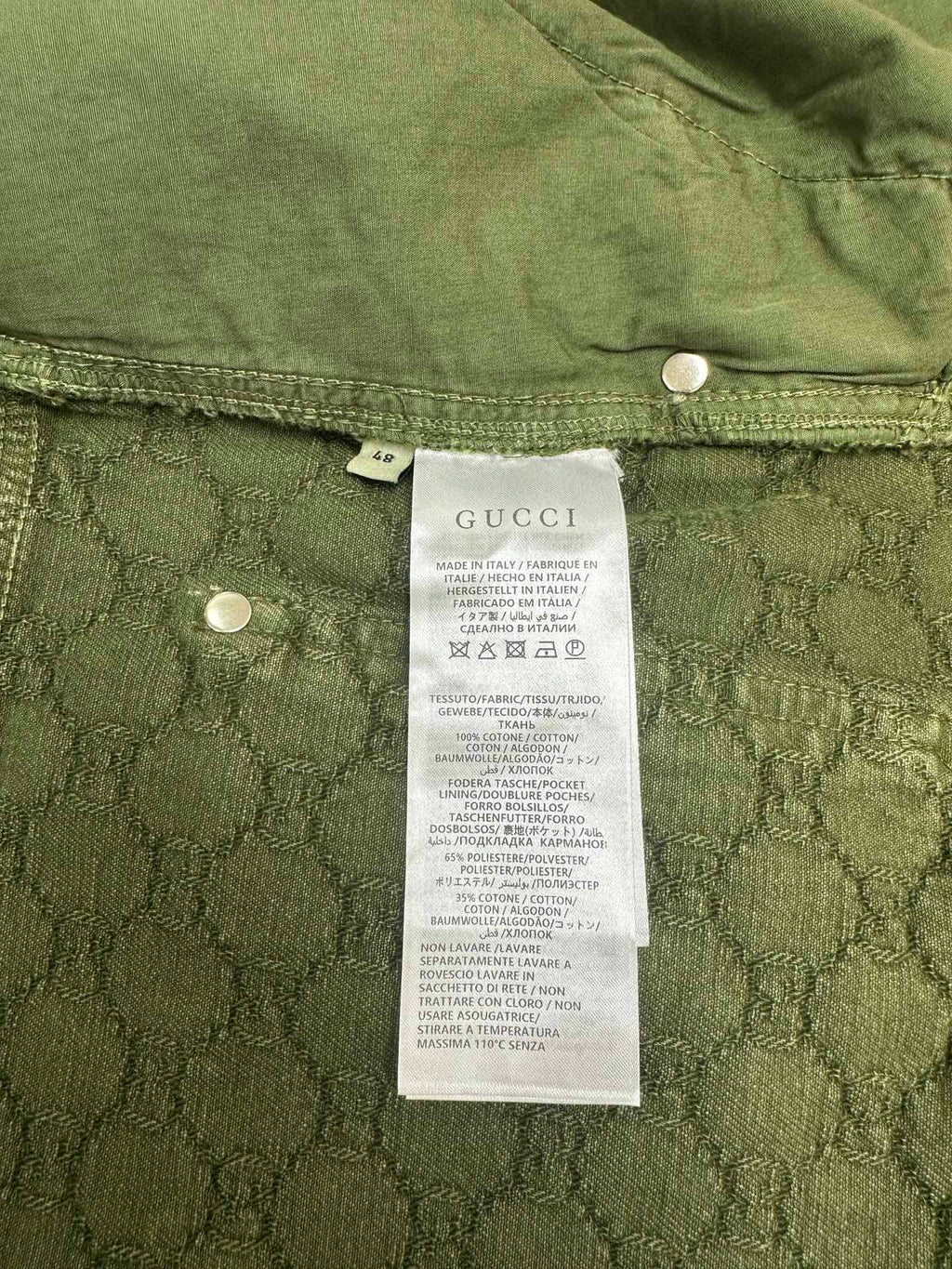 Green Gucci shorts showing care label and interior waistband buttons.