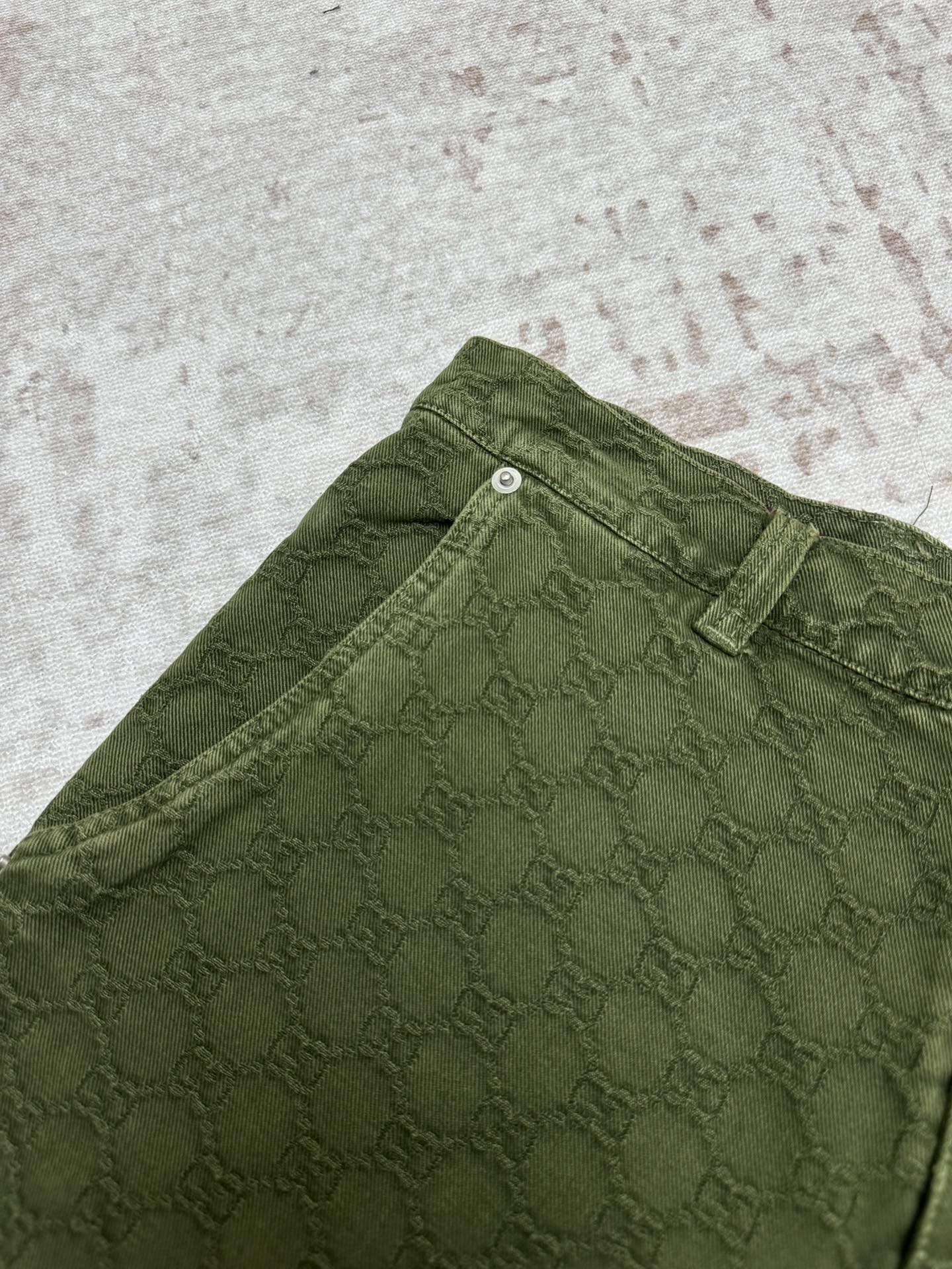 Green Gucci shorts fabric detail with waistband and belt loop.