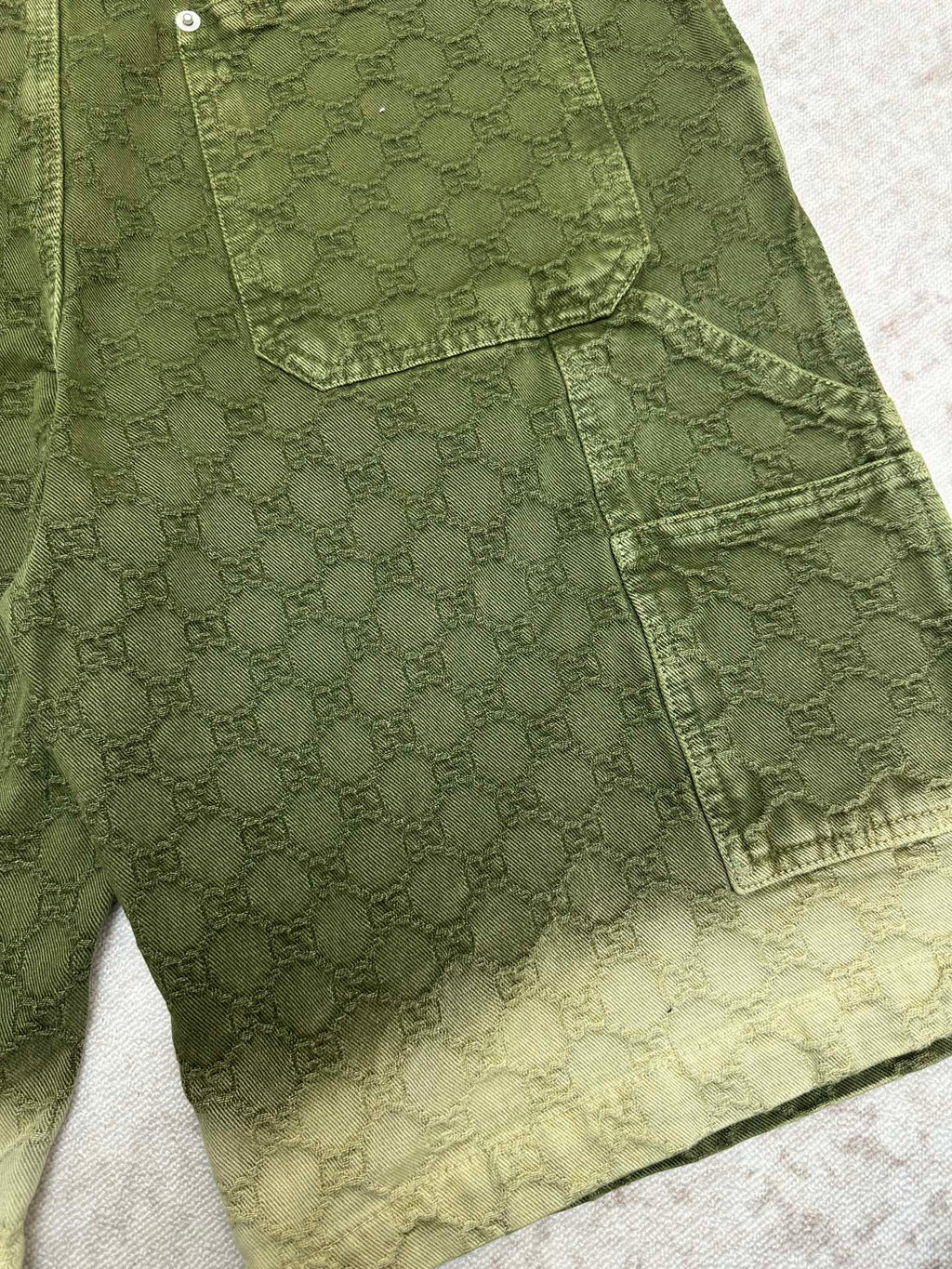 Green Gucci shorts front with cargo pocket and scalloped hemline detail.
