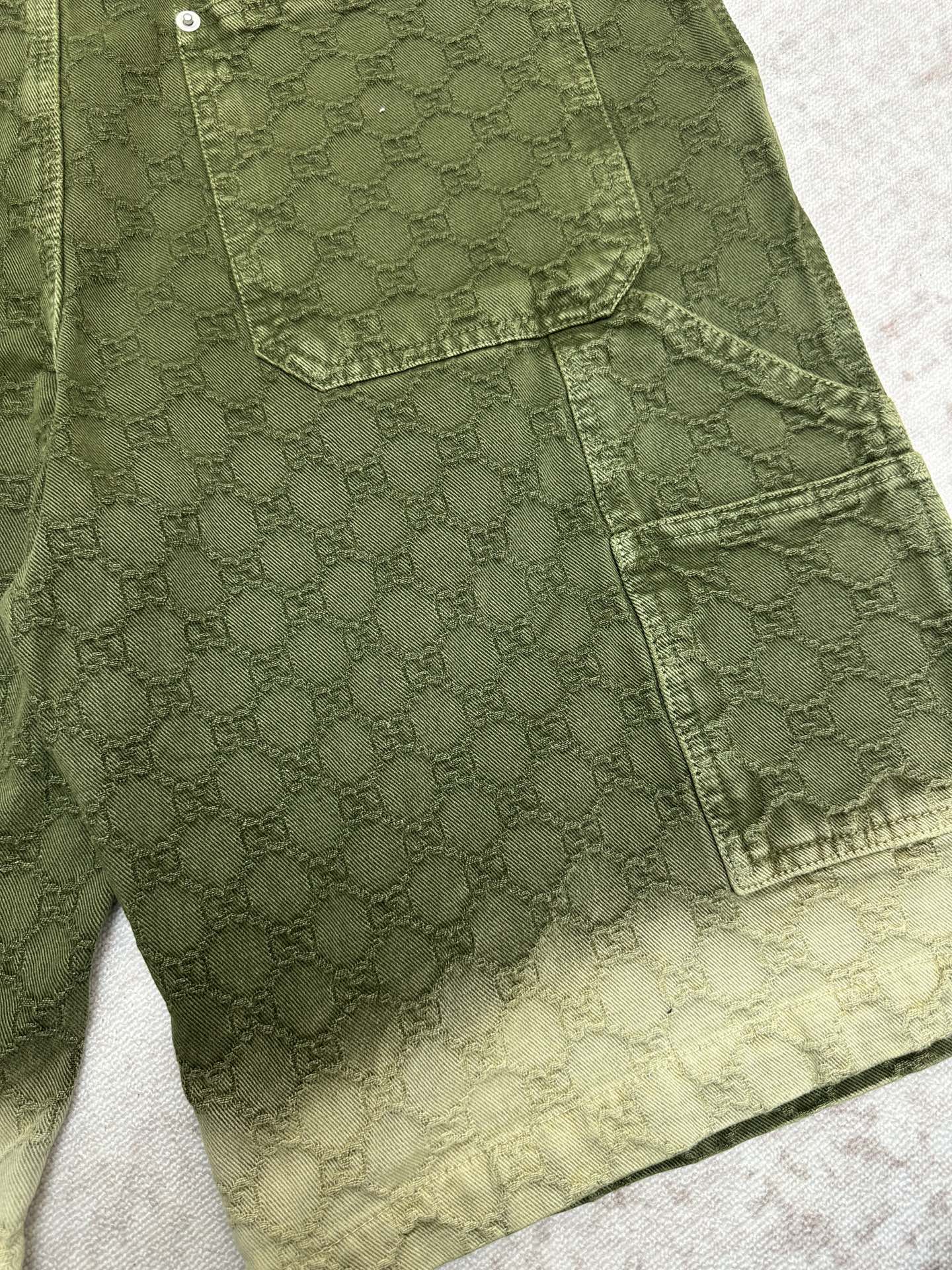 Green Gucci shorts front with cargo pocket and scalloped hemline detail.