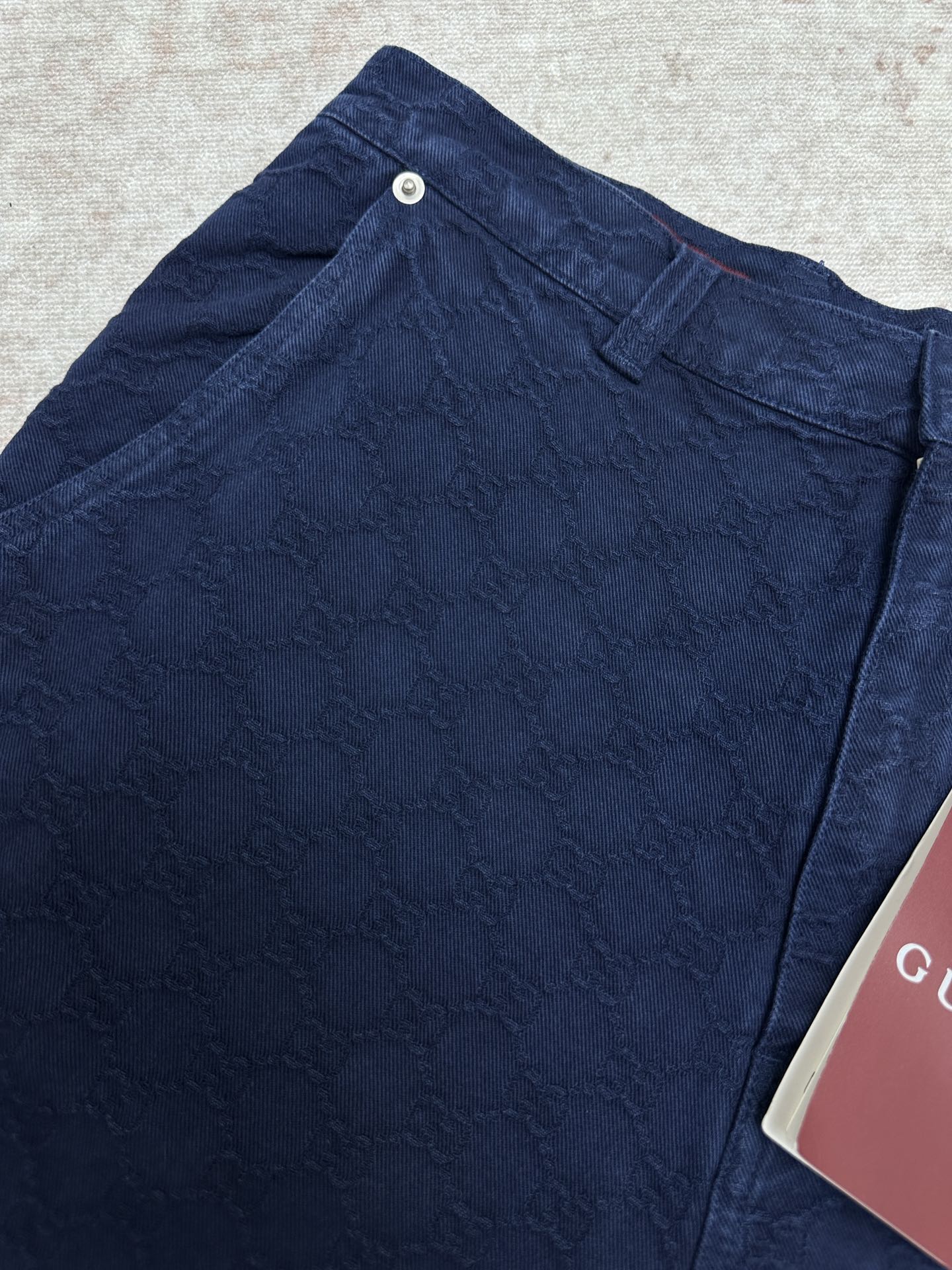 Blue monogram shorts close-up with snap button waistband and belt loops