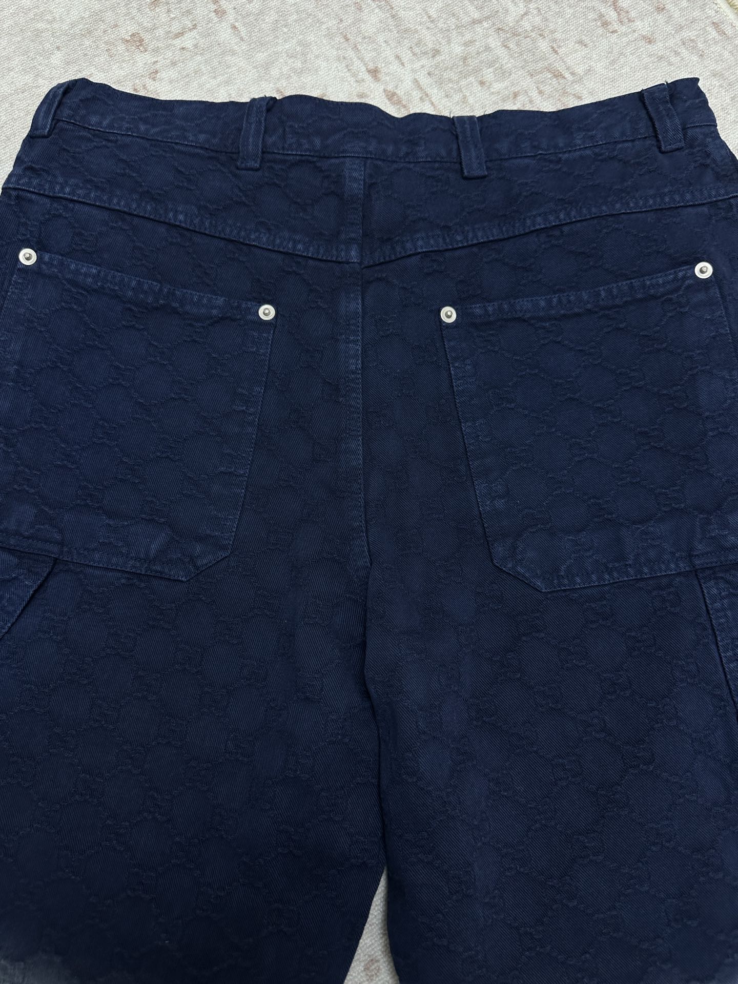Blue monogram shorts with two back flap pockets and metal snap buttons