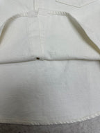 White shirt hem detail with stitched center seam and button placket