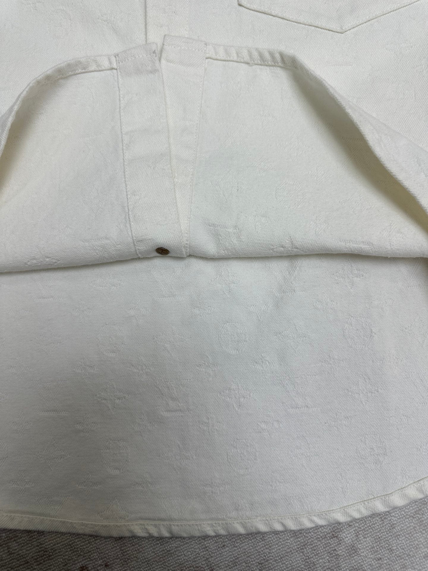 White shirt hem detail with stitched center seam and button placket