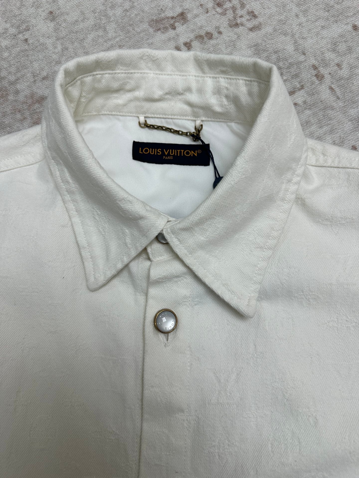 White button-up shirt collar with top button and Louis Vuitton neck tag