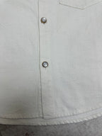 White button-up shirt front with two metal buttons on placket