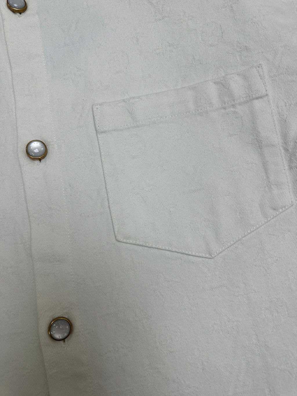 White button-up shirt with single chest pocket and metal button closure