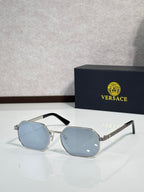 Versace sunglasses with silver frames and light blue hexagonal lenses.