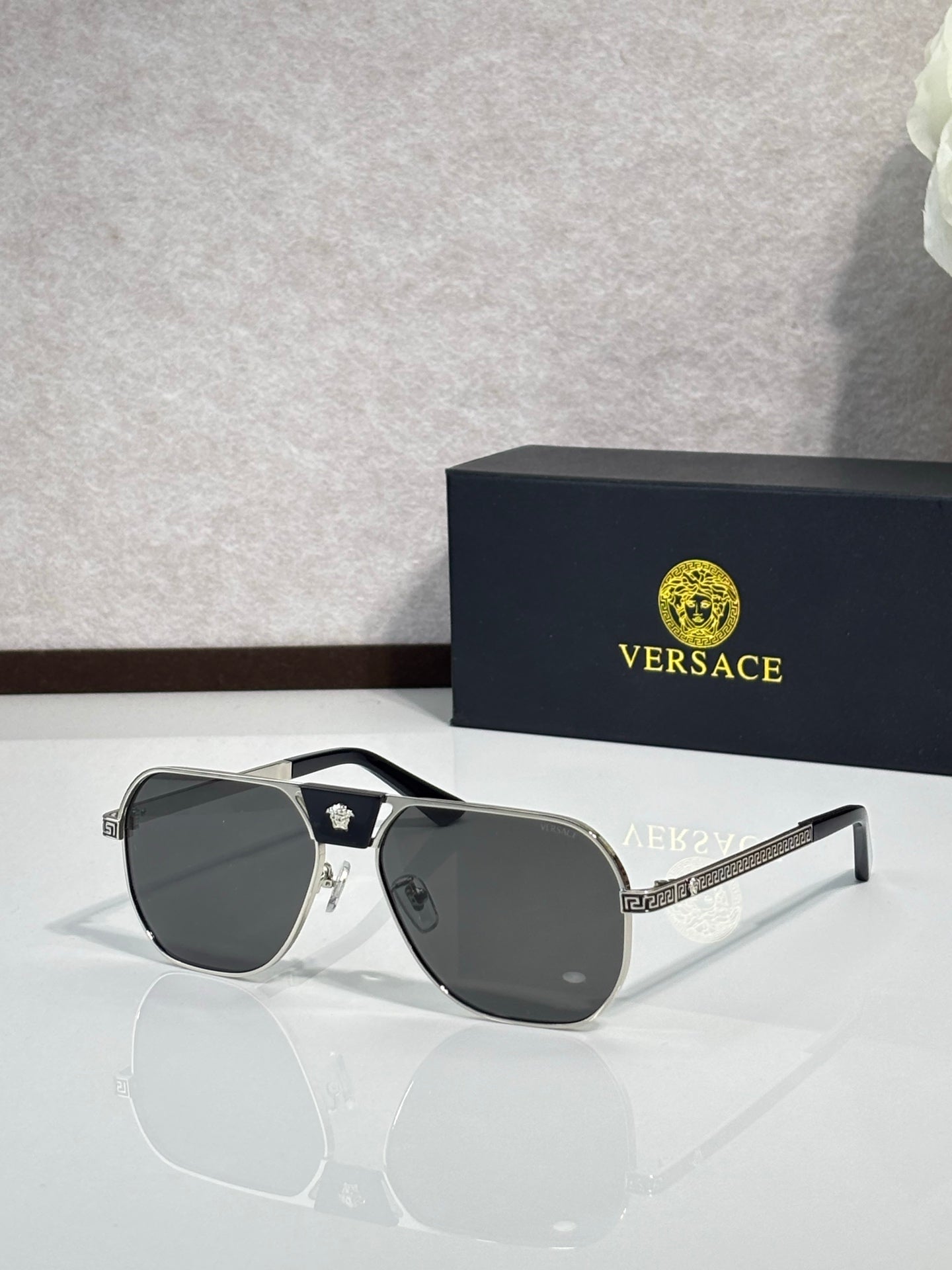 Versace sunglasses with black frame and dark gray lenses, shield-like square silhouette