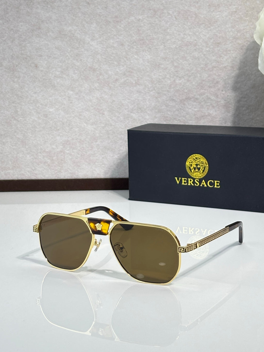Versace sunglasses with gold-brown frame and dark lenses, square aviator style