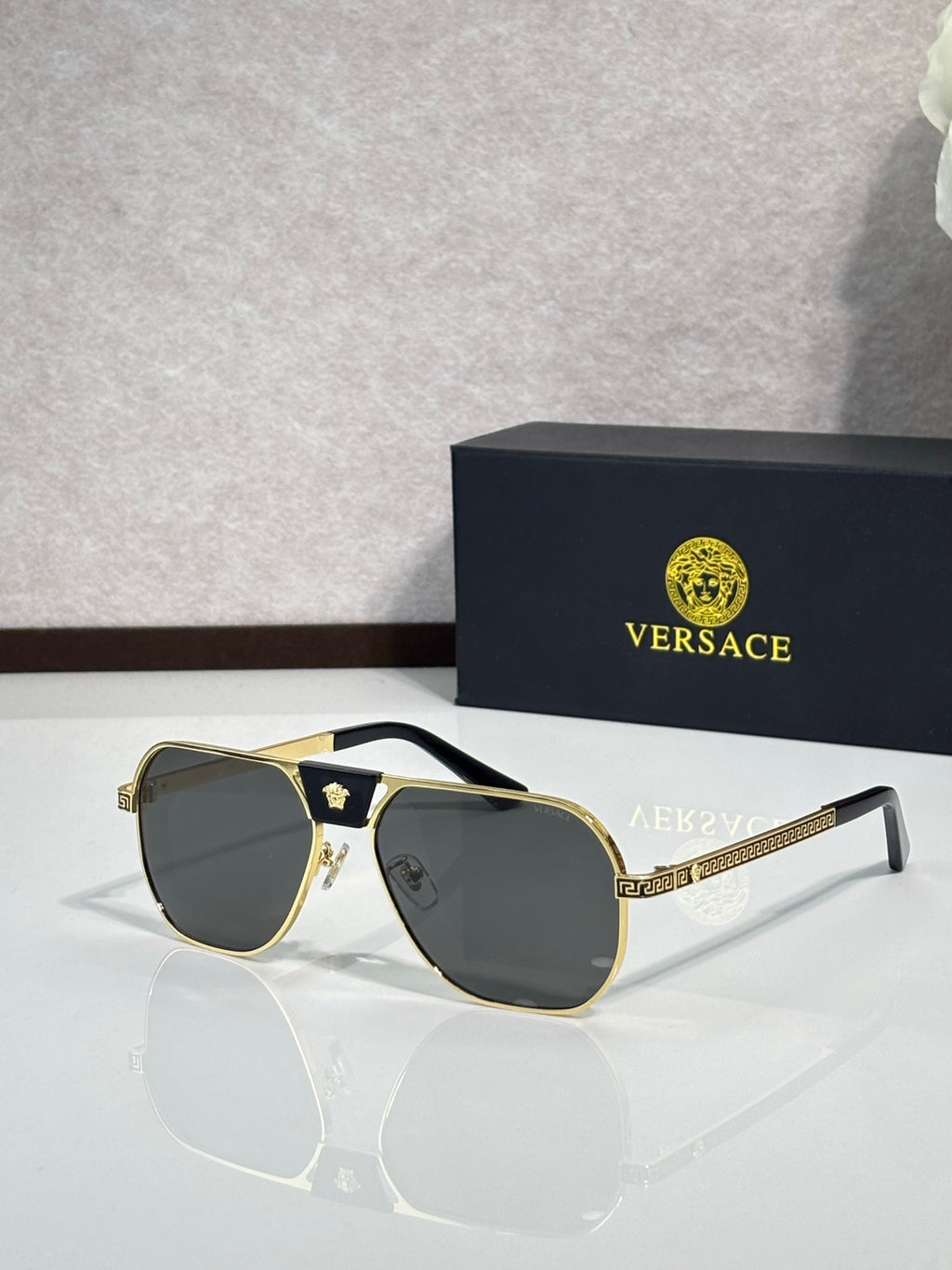 Versace sunglasses with gold frame and dark gray lenses, square aviator style