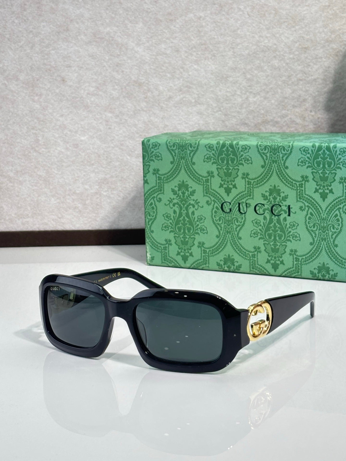 Gucci sunglasses, dark tortoise frames with navy lenses and gold GG detail.