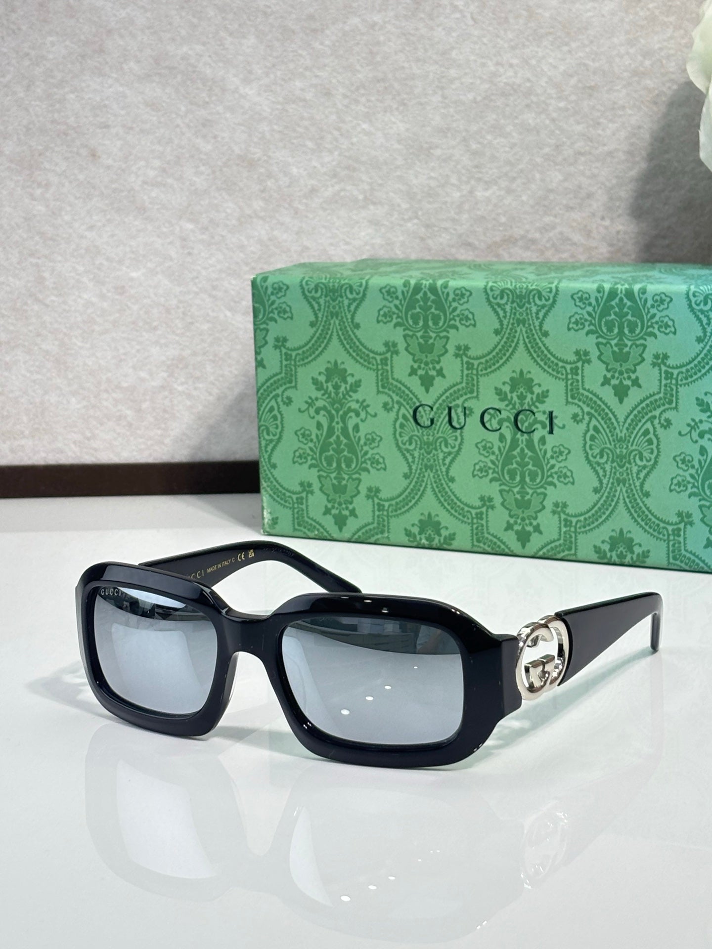 Gucci sunglasses, dark navy frames with black lenses and silver GG emblem.
