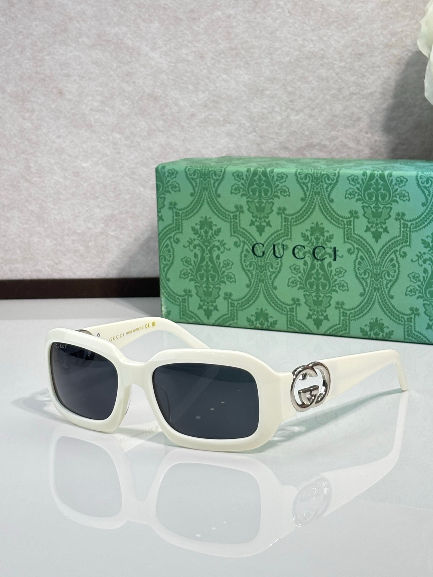 Gucci sunglasses, white square frames with dark lenses and GG logo on temple.