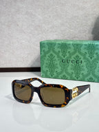 Gucci sunglasses, tortoise frames with golden lenses and gold GG emblem.