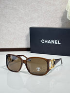 Chanel glasses with tortoiseshell frame and medium-brown lenses, gold-tone logo accents