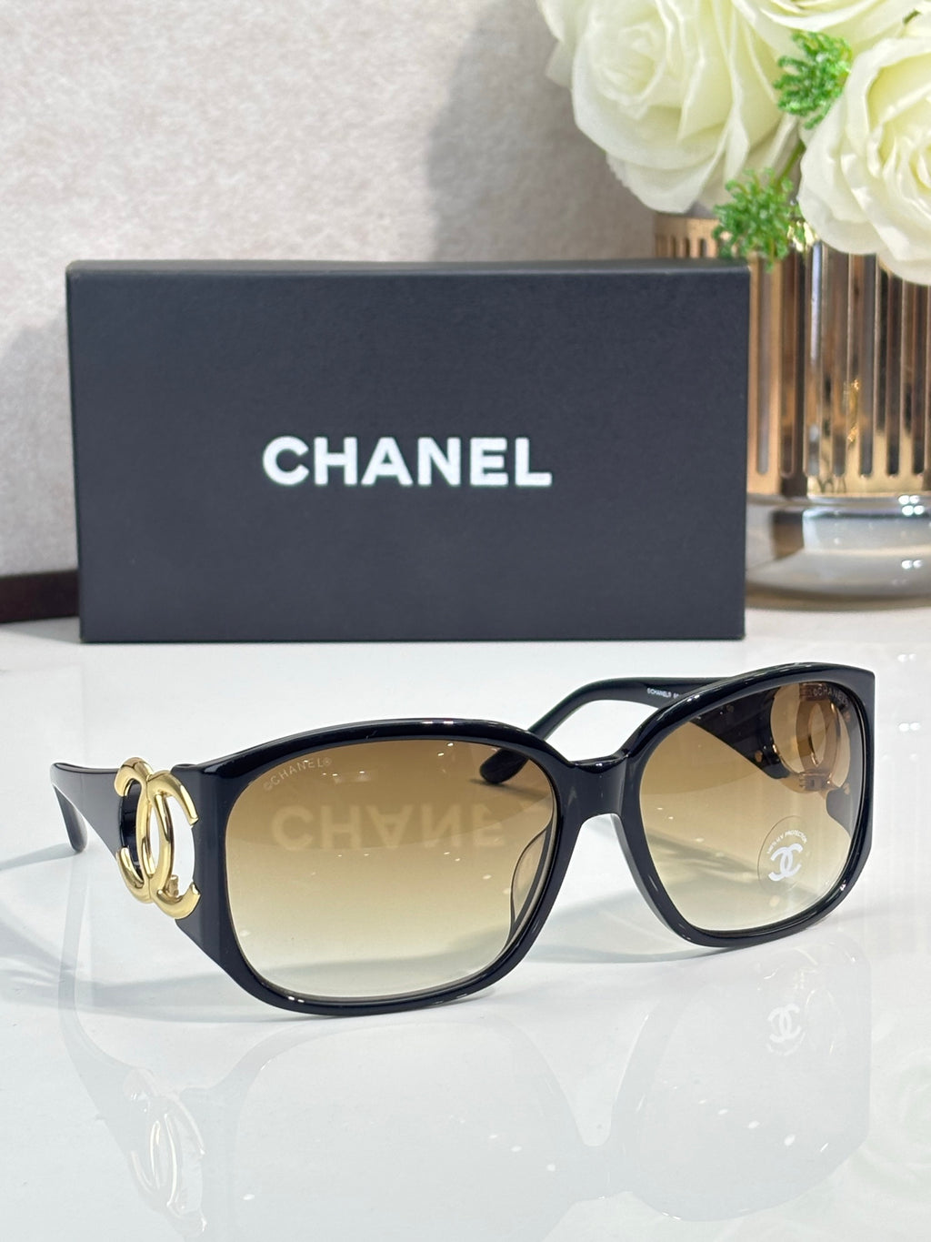 Chanel glasses with dark tortoiseshell frame and tinted amber lenses, gold-tone hinges