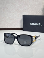 Chanel glasses with black frame and smoky gray lenses, gold-tone logo accents
