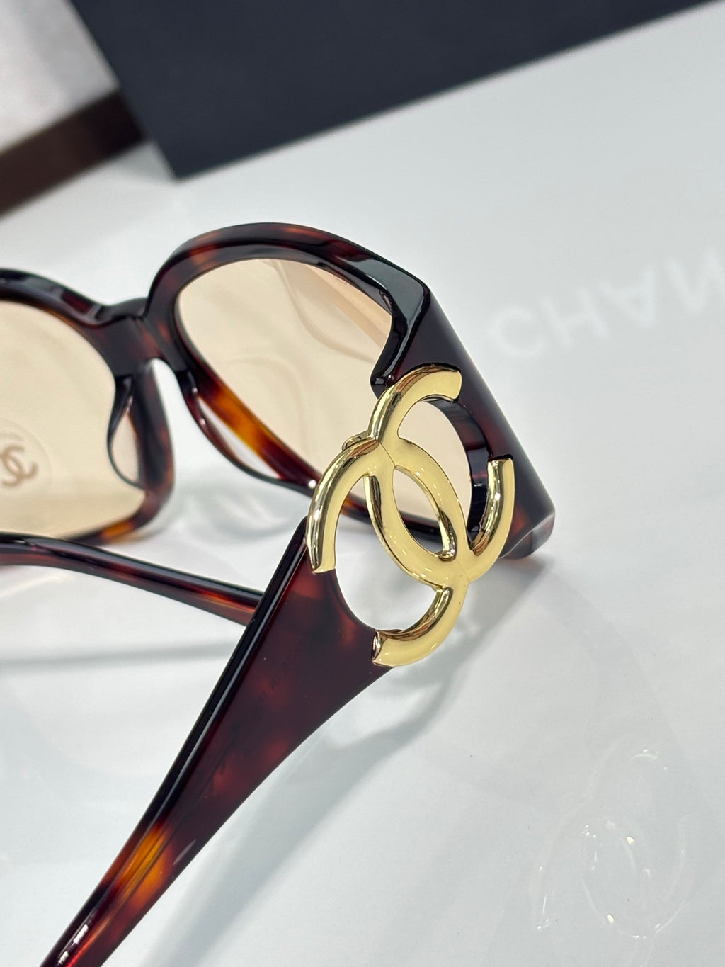 Chanel glasses close-up of tortoiseshell frame with gold-tone logo hardware