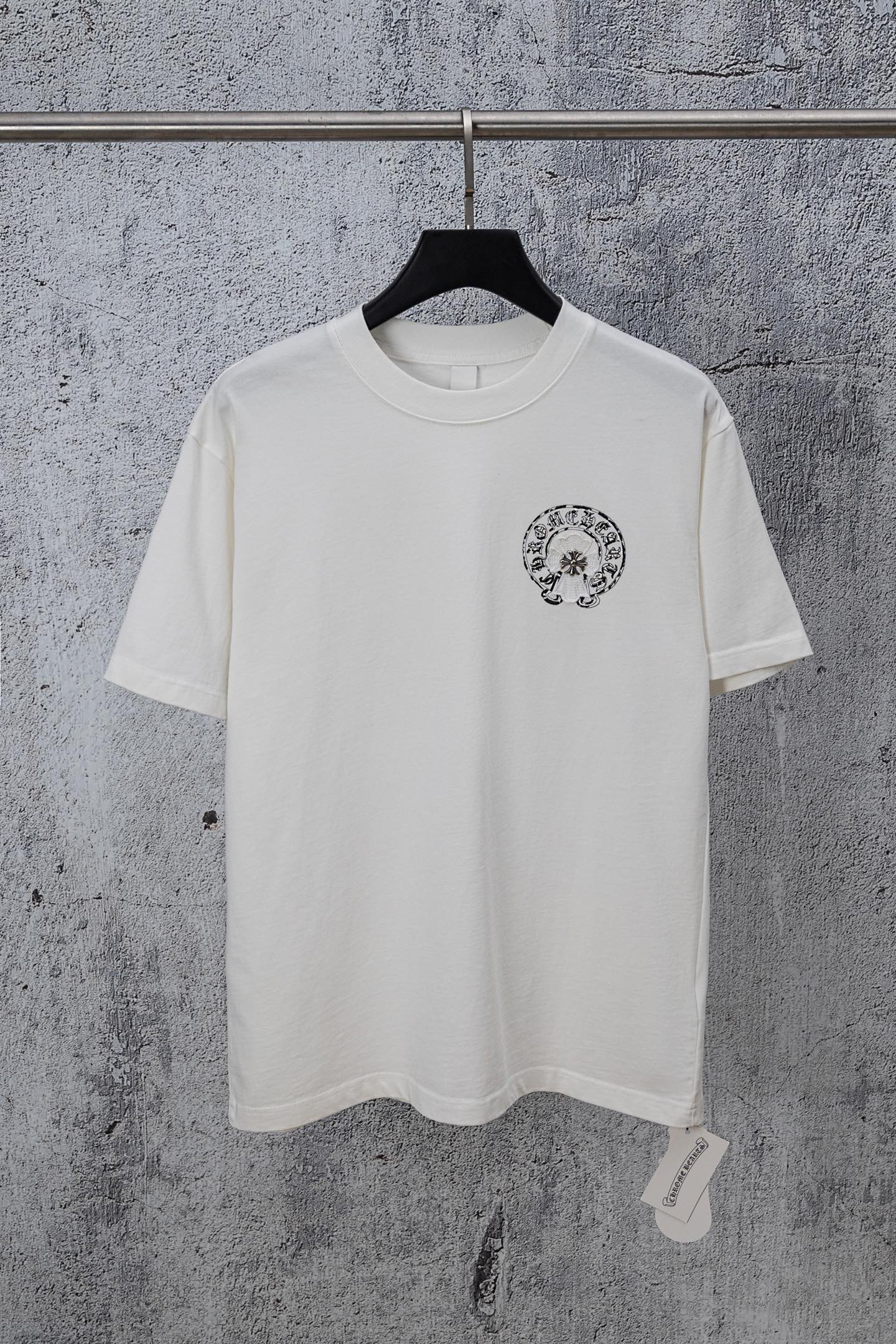 White chrome short T-shirt with small circular crest graphic on the chest