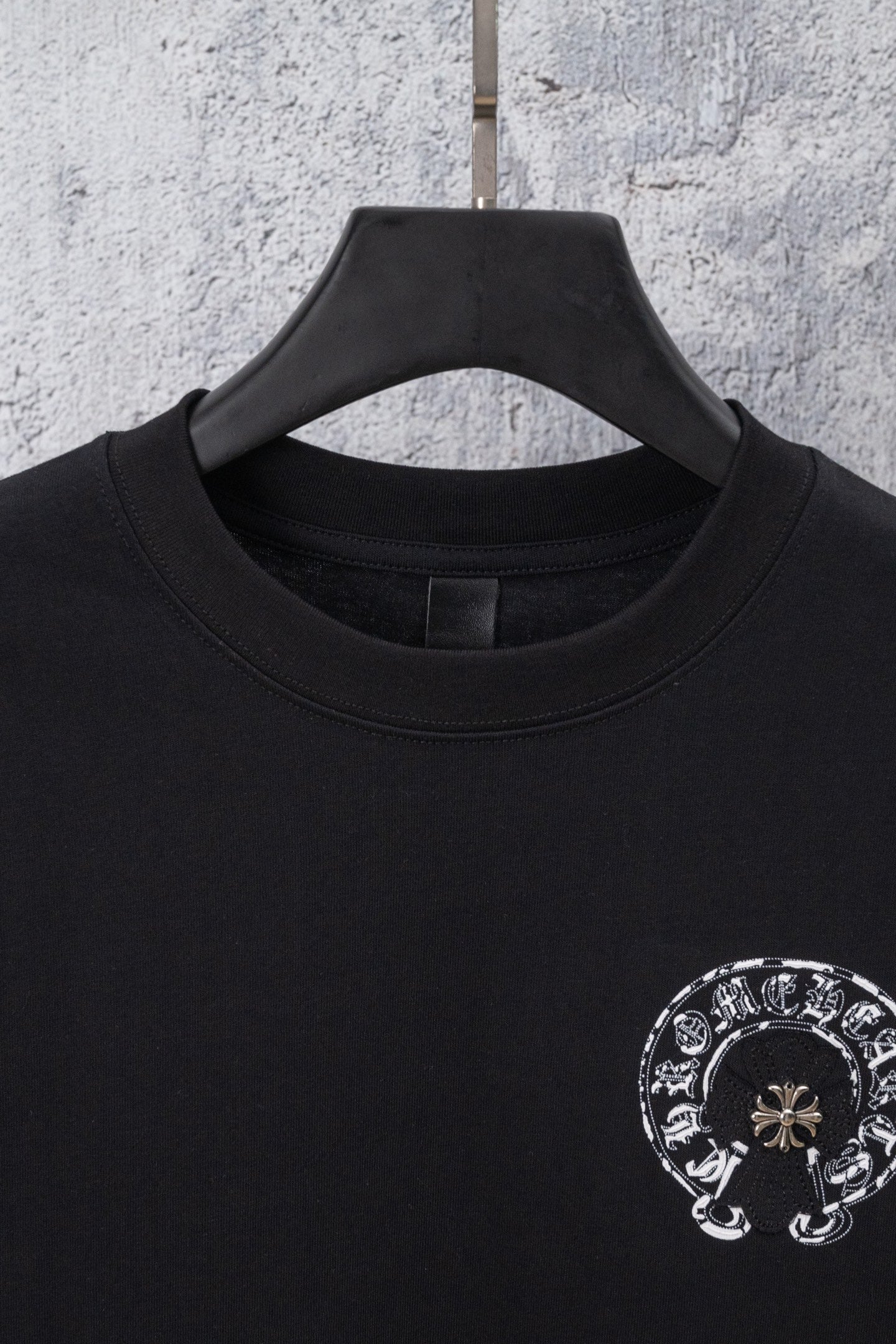 Black crewneck t-shirt with circular chrome-style graphic