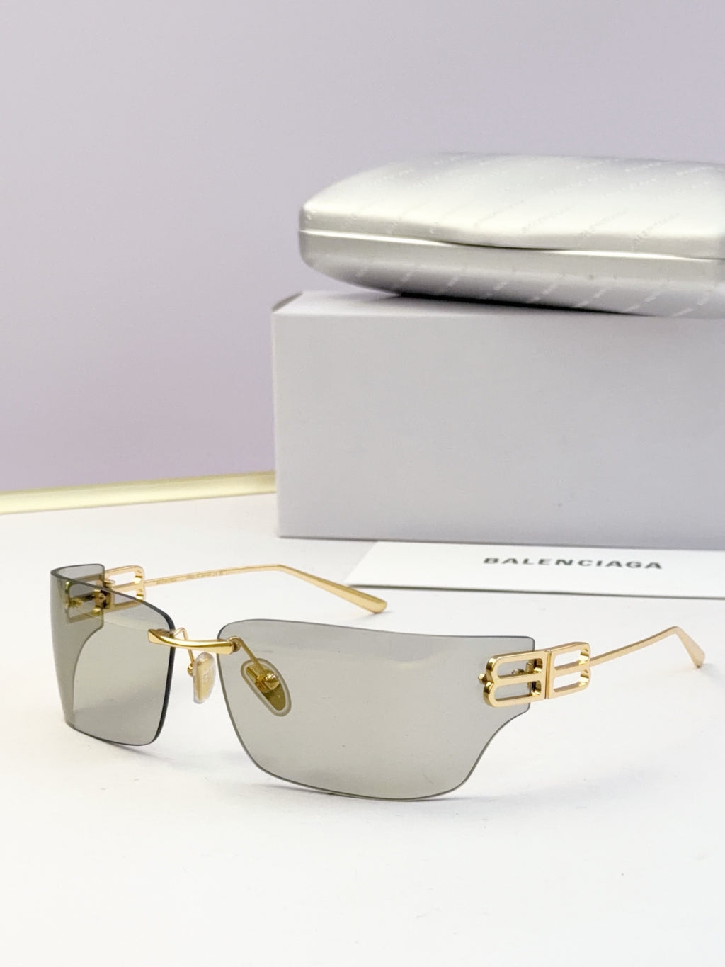 Rectangular pale sunglasses with clear lenses and metallic gold frame hardware