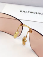 Close-up of gold-tone sunglasses bridge with tinted lens and temple arm