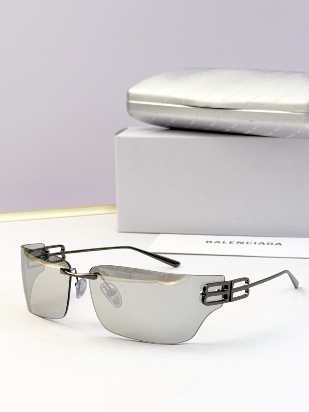 Square-edge sunglasses with clear dark lenses and metallic gold bridge detail