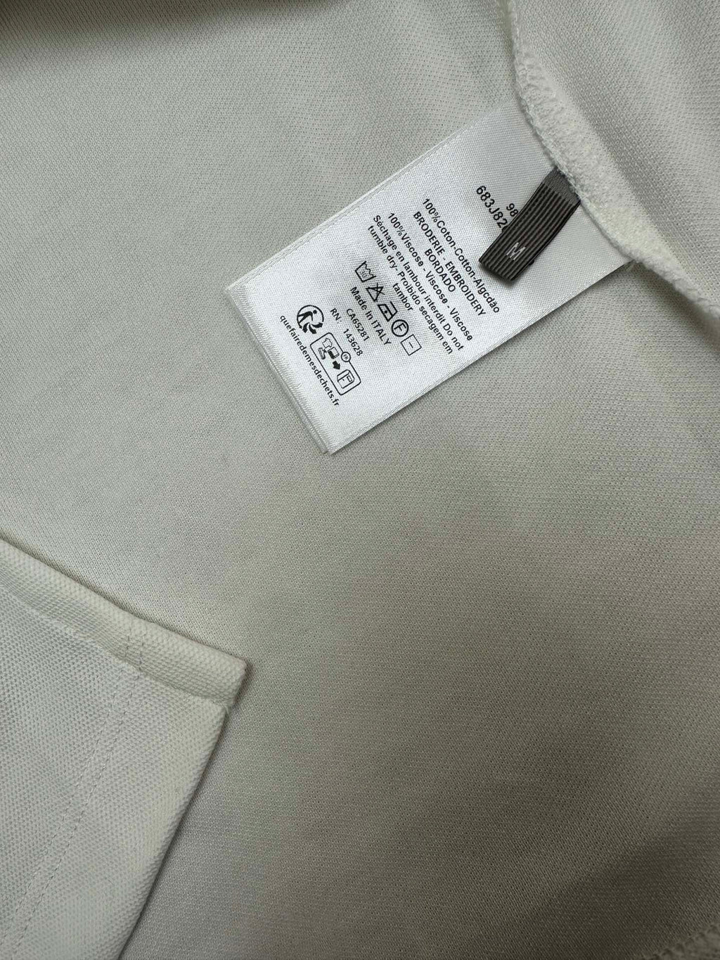 White polo fabric tag near collar and button placket