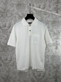 White short-sleeve polo shirt with black buttons and chest pocket