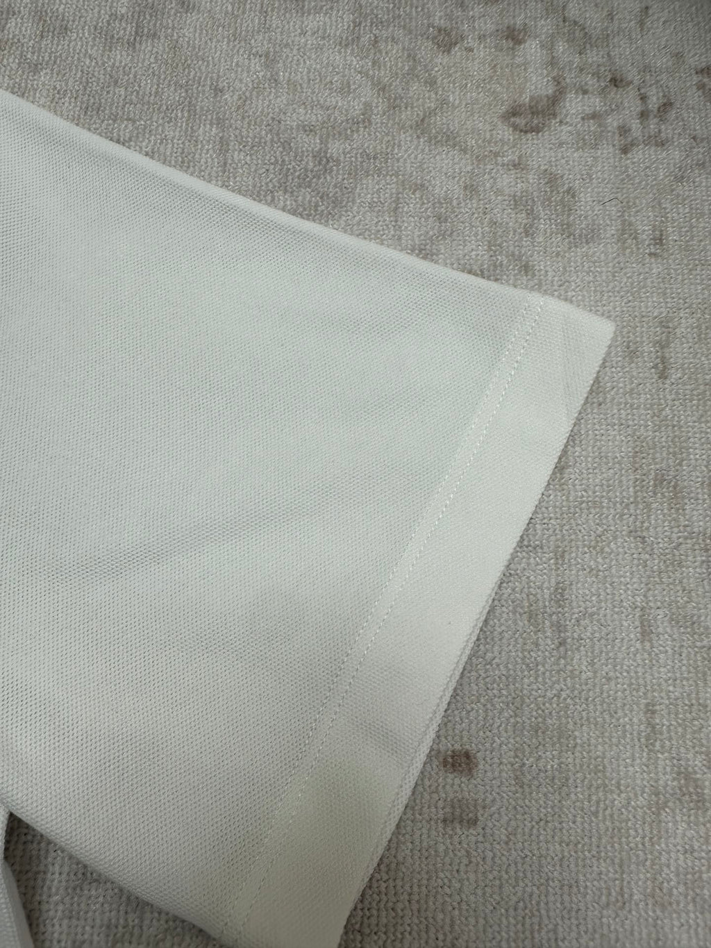 White polo fabric detail with stitched edge at hem