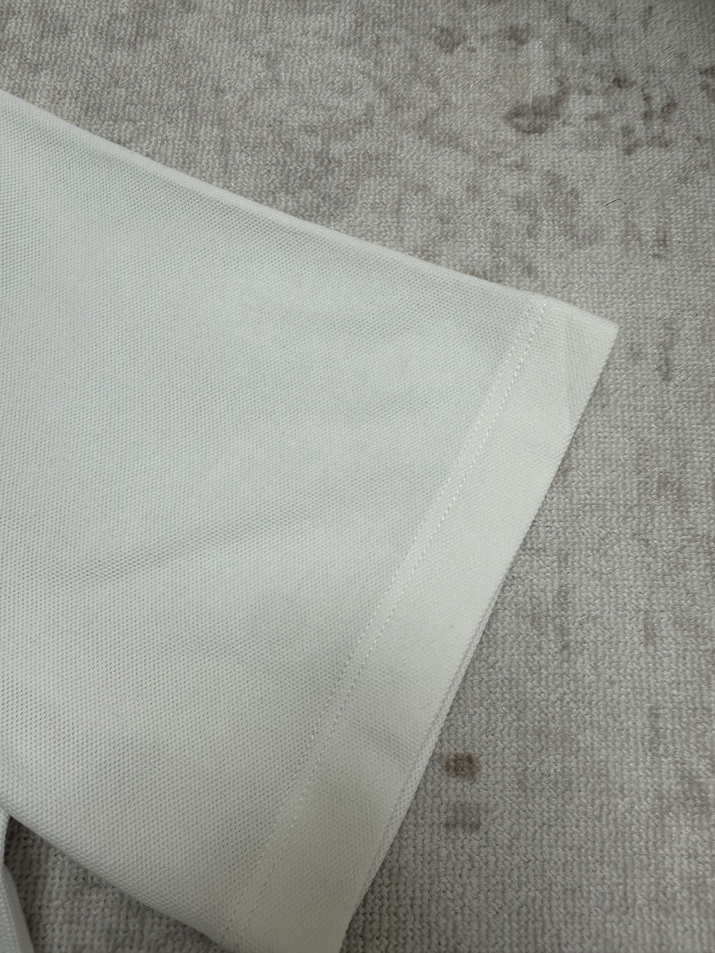 White polo fabric detail with stitched edge at hem