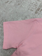Pink polo shirt fabric close-up at sleeve and side seam