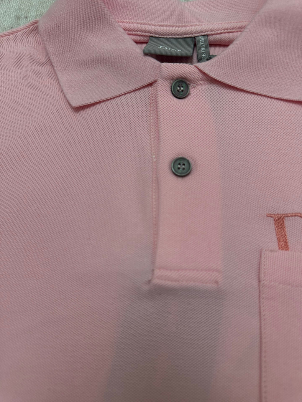Pink Dior polo shirt chest close-up with two-button placket