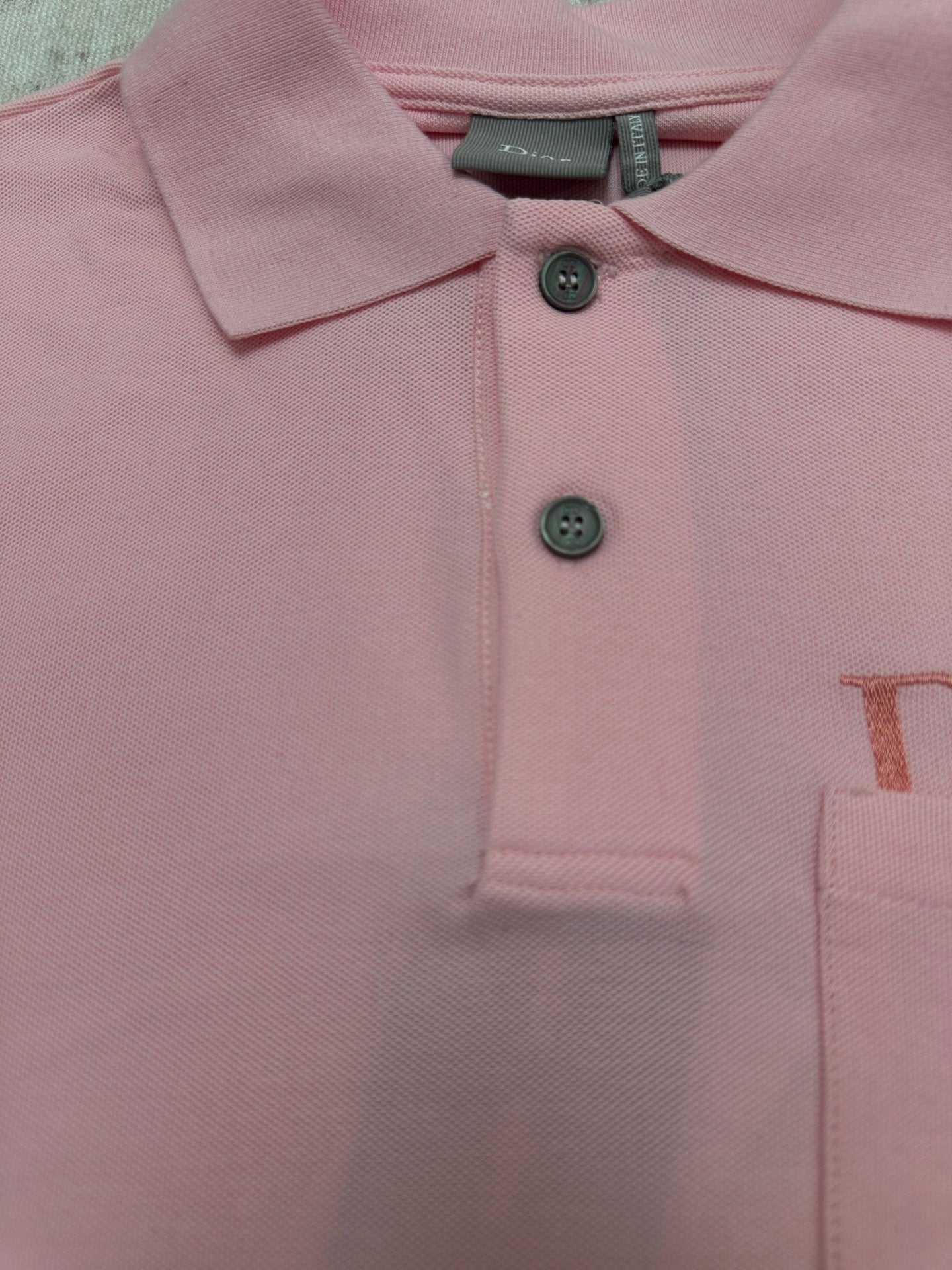 Pink Dior polo shirt chest close-up with two-button placket