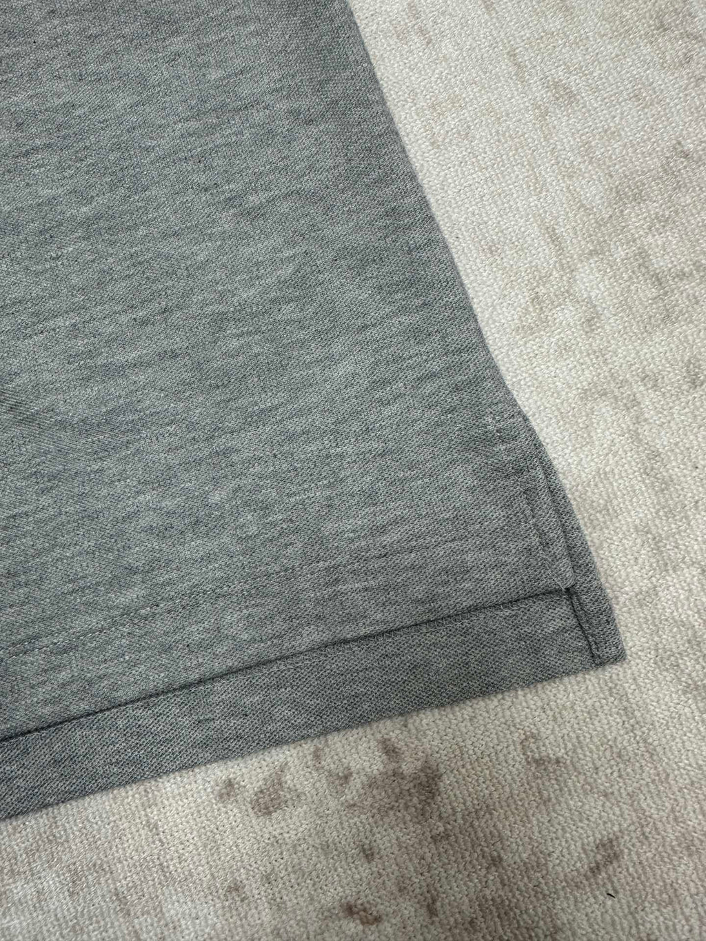 Heather gray short-sleeve polo shirt sleeve and curved hem detail