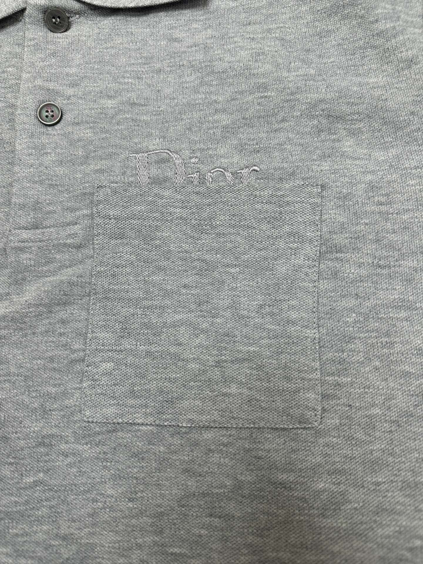 Heather gray polo shirt with chest logo, pocket, and two-button front